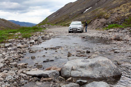 Driver sitting in car for driving on mountain riverの写真素材