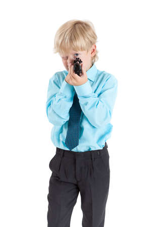 Portrait of Caucasian blond child aiming with black gun in hands, isolated on white backgroundの写真素材