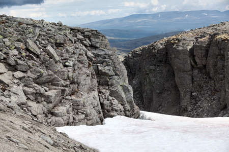 Mountain passage with snow field is in the old massif Khibins at Kola peninsula