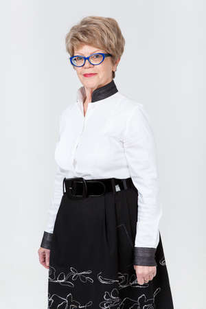 Portrait of smiling senior Caucasian woman, gray backgroundの写真素材