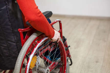Close up cropped view of handicapped person sitting invalid wheel-chair indoors, copy spaceの写真素材