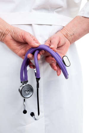 Female doctor holding stethoscope in hands behind his back, close-up, isolated on white backgroundの写真素材