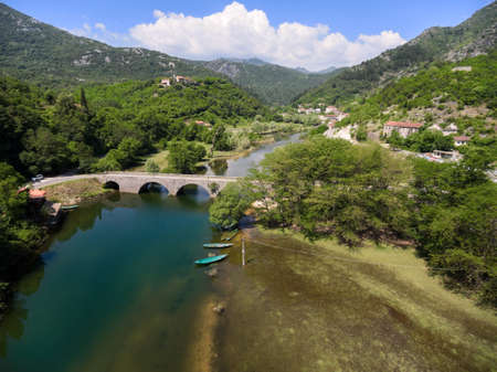 Small town is on river Crnojevica with arch bridge across. National park in Montenegroの写真素材