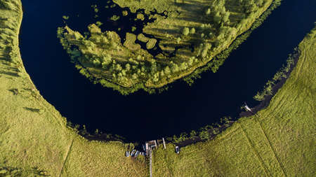Forest river watercourse in marsh. Wooden rowboats moored on the shore. Aerial view. Northern Karelia, Russiaの写真素材