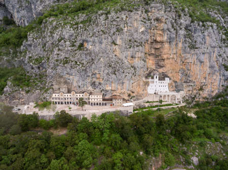 Square of upper Serbian Orthodox monastery of Ostrog with walking people. Aerial view. Montenegro. View from droneの写真素材