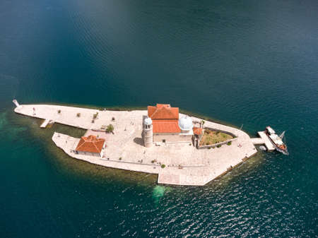 Top view at artificial island Gospa od Skrpjela with Roman Catholic church of Our Lady of the Rocks. Adriatic sea, coast of Perast in Kotor Bay. Montenegroの写真素材