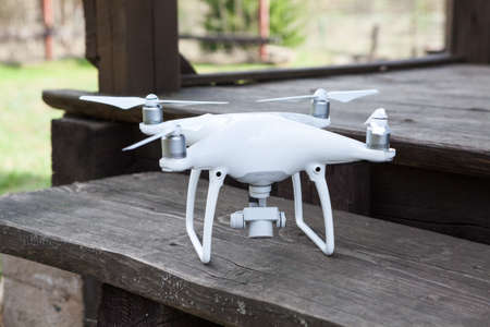 Moscow, Russia - circa May, 2016: White quadrocopter Dji Phantom 4 is on wooden porch. Phantom 4 is...