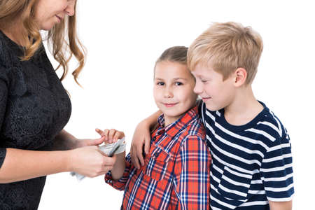 Brother and sister taking pocket-money from mother, isolated white backgroundの写真素材