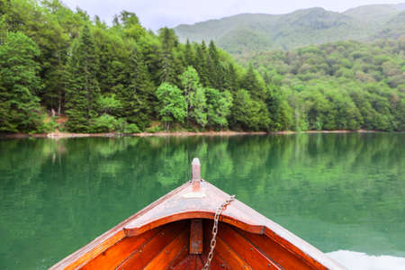 View at the green water and evergreen forest on the Biograd lake from wooden row boat. Montenegro,...