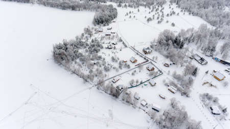 Aerial view at Russian winter village on the frozen lake shore. Timber houses and farms. Russiaの写真素材
