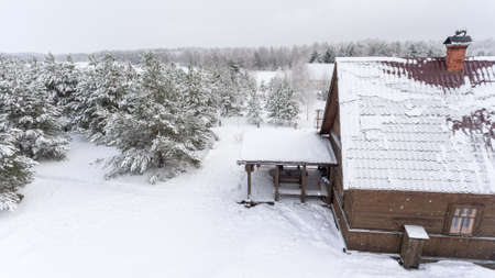 Timber rural house with summer porch is in winter forest. Russain countryside, Russiaの写真素材
