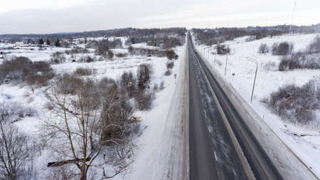 Empty snowy slippery federal three line highway passing through the Russian village. Top viewの写真素材