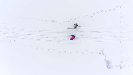 Two sporty woman skiing on the snowy icy lake. Top viewの写真素材