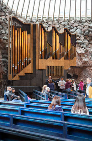 HELSINKI, FINLAND - CIRCA SEP, 2016: People sit on benches in the church Temppeliaukio. The pipe organ is near stone wall. The temple is carved into the rockのeditorial素材