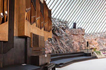 HELSINKI, FINLAND - CIRCA SEP, 2016: The pipe chair organ is near stony wall in the Finnish church Temppeliaukio. The temple is carved into the rock.のeditorial素材