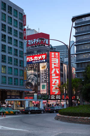TOKYO, JAPAN - CIRCA APR, 2013: Contemporary illuminated buildings with lot of banners are in the...