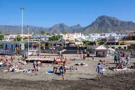 COSTA ADEJE, TENERIFE, SPAIN-CIRCA 2016, JAN: People sunbathing on the grey sand of Blue Flaged beach of the Playa Fanabe. South of Tenerife island. The Playa Fanabe is a biggest city beachのeditorial素材