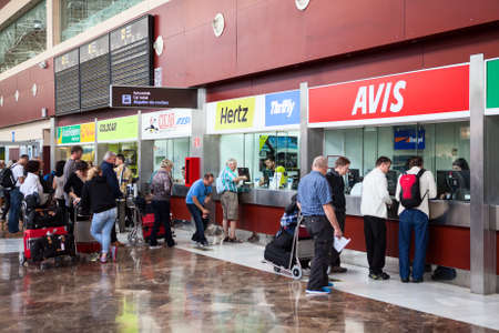 SOFIA REINA AIRPORT, TENERIFE, SPAIN â CIRCA DEC, 2015: Stands of car rental companies are at the south international airport of Tenerife island. Passengers stand in queue for vehicles hireのeditorial素材