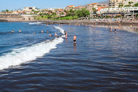 COSTA ADEJE, TENERIFE, SPAIN-CIRCA JAN, 2016: Waves are on black sand beach of Playa Fanabe resort. The Playa Fanabe is a Blue flagged city beachのeditorial素材