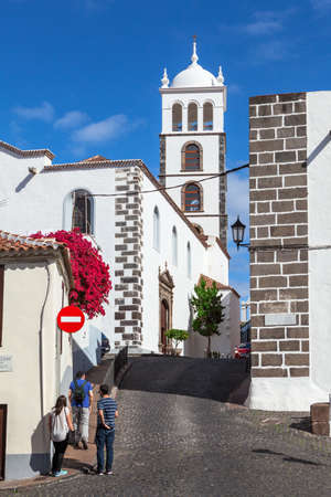 GARACHICO, TENERIFE, SPAIN-CIRCA JAN, 2016: Belltower of the Church of Saint Anna (Iglesia de Santa Ana). Car drives cobbled road. The Garachico is an ancient town on the northのeditorial素材