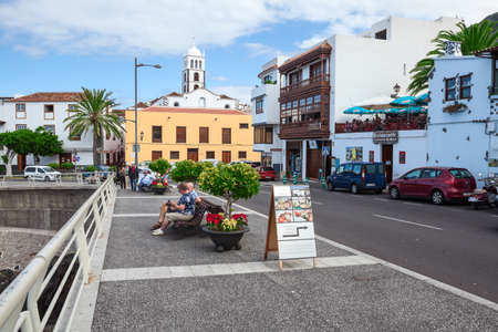 GARACHICO, TENERIFE, SPAIN-CIRCA JAN, 2016: Senior people seat near road TF-42 passing along shoreline through the streets of Garachico town. The Garachico is an ancient town on the northのeditorial素材