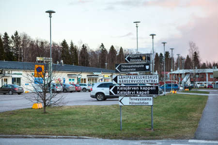 KALAJARVI, FINLAND â CIRCA, DEC, 2015: Direction signs to library, to church and hospital are near grocery store in provincial small town. Living is in northern part of countryのeditorial素材