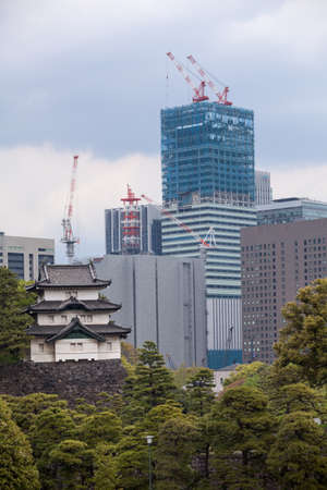 TOKYO, JAPAN - CIRCA APR, 2013: Modern high-rise buildings are under constructions and the Fujimi-yagura three-story tower. View from inner ground of Tokyo Imperial Palace.のeditorial素材