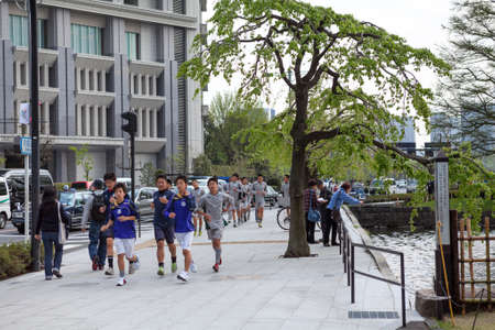 TOKYO, JAPAN - CIRCA APR, 2013: Japanese youths jog through the city center. Schoolboys training is on urban streets.のeditorial素材