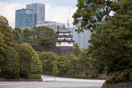 TOKYO, JAPAN - CIRCA APR, 2013: View at the Fujimi-yagura three-story tower on sky scrapers background. Inner ground of Tokyo Imperial Palace. The main residence of the Emperor of Japan.のeditorial素材