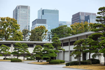 TOKYO, JAPAN - CIRCA APR, 2013: Modern high-rise buildings and the inner ground of Tokyo Imperial Palace. The East Garden with green trees and plants. Center of Tokyo cityのeditorial素材