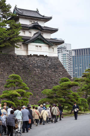 TOKYO, JAPAN - CIRCA APR, 2013: Access to the inner ground - group of visitors is near the Fujimi-yagura three-story tower. Tokyo Imperial Palace is the primary residence of the Emperorのeditorial素材