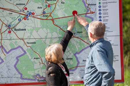 Mature husband and wife pointing on the map, finding location place