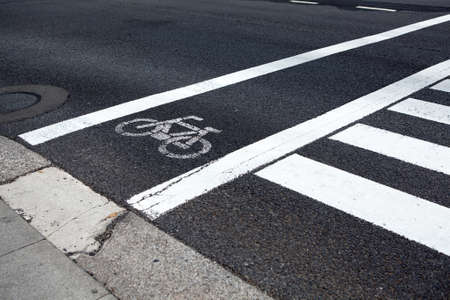 Bike lane along pedestrian road crossing, close up view at white painted marksの写真素材