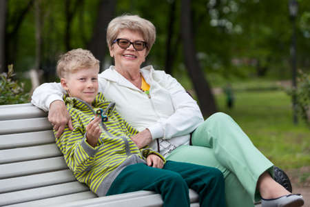 Smiling grandson playing with spinner gadget, happy grandma hugging boyの写真素材