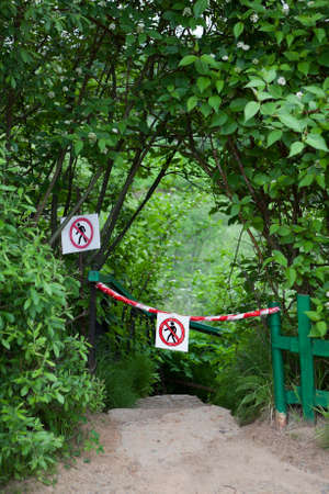 Signs with signs passage forbidden, descent the stairs down among the bushesの写真素材