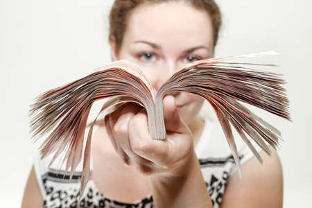 Close-up portrait of woman holding cash Russian roubles in hand, white background