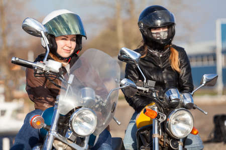 Portrait of two European pretty female bikers with classic and street style bikes in cityの写真素材