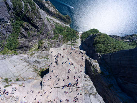 Flat rock Preikestolen over fjord Lysefjorden is natural attraction. Top view and flight up above cliff. Preacher's Pulpit or Preacher's Chair is in Forsand, Rogaland. Norwayの写真素材