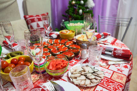 Festive table with food served with red ornament tablecloth is ready for Christmas or New Year celebration. Russiaの写真素材