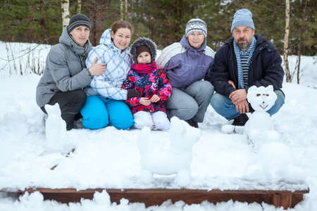 Big family with five persons making snowman, animals figure from snow. Wintertimeの写真素材