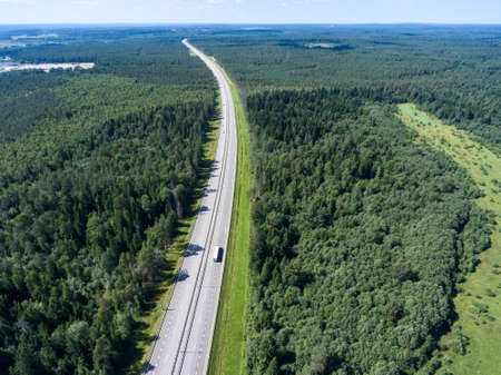 Long and wide highway going to horizon, freight semitrailer driving on lane, aerial viewの写真素材