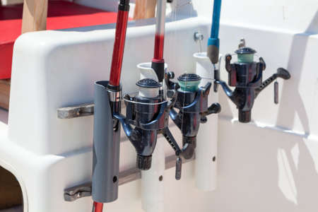 Fishing tackles are inserted in holders on motorboat, close up viewの写真素材