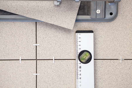 Tile-cutter, building level for tile paving, background on floorの写真素材