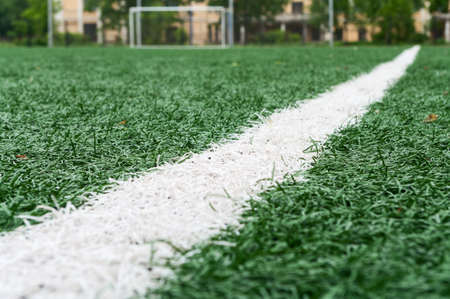 Artificially turfed football field with green grass and white line, close up viewの写真素材