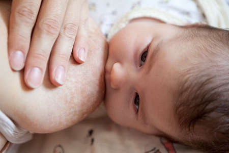 Human milk feeding with female breast, newborn baby breastfeeding