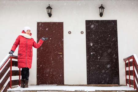 Double door entrance of townhouse with high porch and woman showing hand for choiseの写真素材