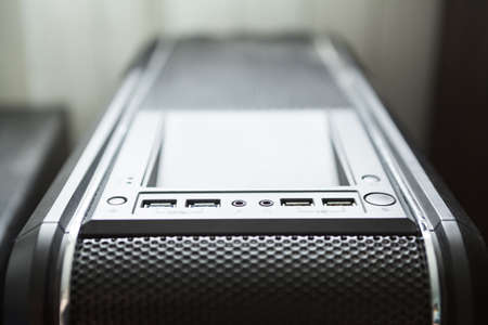 Black pc tower case with usb connection sockets, power and reset buttons, close-up view