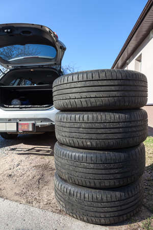 Four big wheels with summer tire are ready for loading inside the trunk of passenger carの写真素材