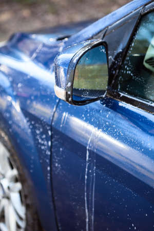 Car side mirror and door with foam during car washing, close-up viewの写真素材