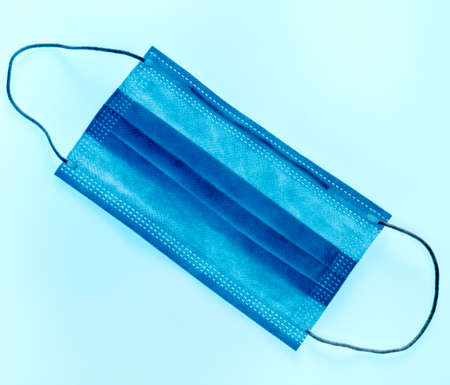 Mess, infected medical mask concept, a blue background